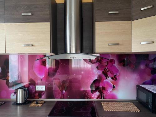 a kitchen with a stove top oven with pink wallpaper at Cat Garden Elegant Apartments Riga in Rīga