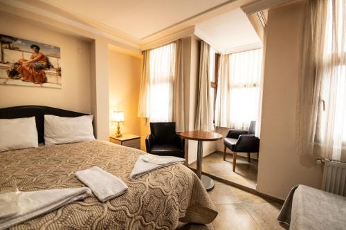 um quarto de hotel com uma cama, uma mesa e cadeiras em Sultanahmet Black Pearl Apart Hotel em Istambul