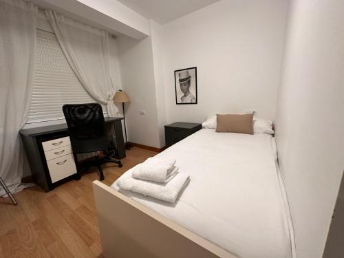 a bedroom with a bed and a desk and a chair at Oktheway Santander Street in A Coruña