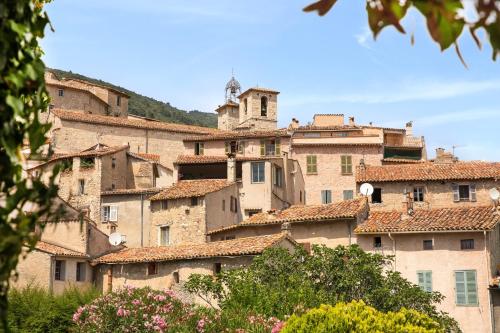 un grand groupe de bâtiments avec une tour d'horloge dans l'établissement La Vicomtesse de Seillans, à Seillans