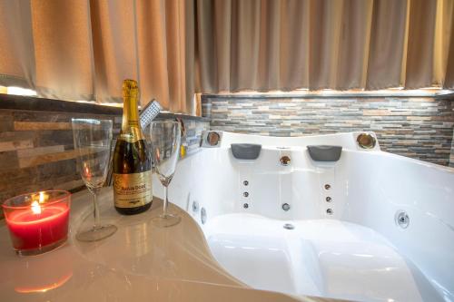 a bottle of wine and two glasses on a bath tub at Virtus Prestige - Rooms & Apartments in Rome