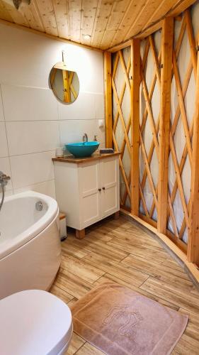 a bathroom with a tub and a toilet and a sink at Jurty nad Sanem in Lutowiska