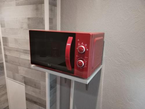 a red toaster oven on a wall at Charmant appartement cosy in Sélestat