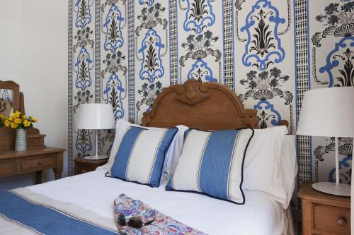 a bedroom with a bed with blue and white wallpaper at The Townhouse Strand in Dunmore East