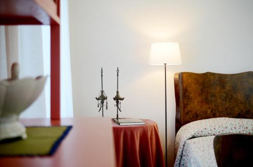 a bedroom with a bed and a table with a lamp at Casa di Mafalda in Mogliano Veneto