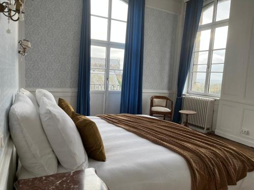 - une chambre avec un grand lit et des rideaux bleus dans l'établissement Mercier de Montigny - Les Chambres du Beffroi - SPA et Massage, à Fougères
