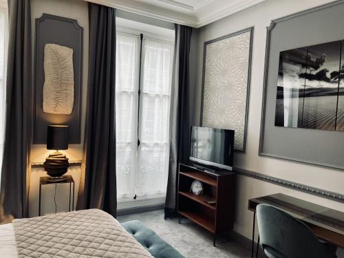 a hotel room with a bed and a television at L'appart du centre in Paris