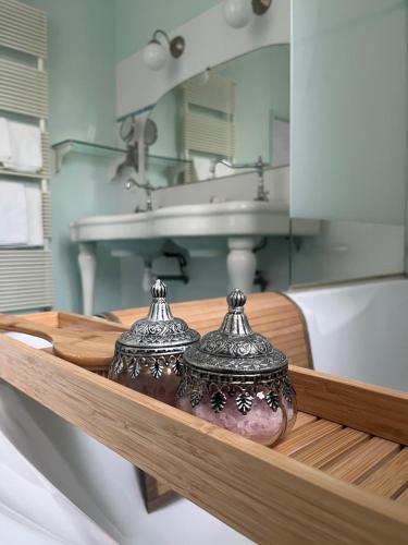 富熱爾的住宿－Mercier de Montigny - Les Chambres du Beffroi - SPA et Massage，浴室设有水槽和架子上的两个花瓶