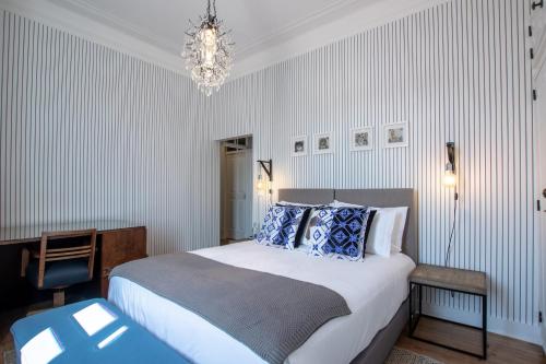 a bedroom with a large bed and a chandelier at Carnot House in Setúbal