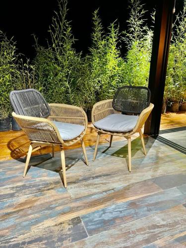two wicker chairs and a table on a patio at leremita biohotel in Silvia