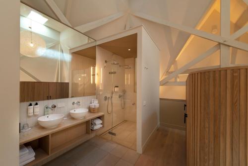 een grote badkamer met 2 wastafels en een douche bij Hotel Arena in Amsterdam
