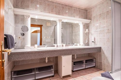 baño con lavabo y espejo grande en Ferienhaus Willms am Gaisberg, en Kirchberg in Tirol