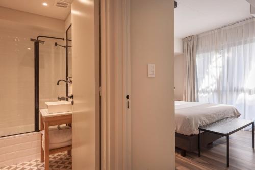 1 dormitorio con 1 cama y baño con ducha en Viví este Increíble Nuevo Depto en San Telmo -332- en Buenos Aires