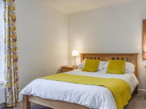 惠特比的住宿－Sunstar Cottage，一间卧室配有一张黄色毯子床