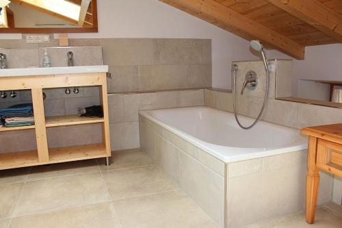 a bathroom with a bath tub and a sink at Fembacher Alm in Seeon-Seebruck