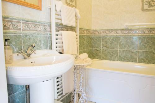 a bathroom with a sink and a bath tub at Maranatha Country House in Blarney