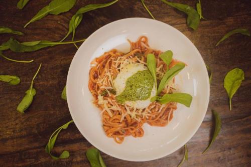 a plate of spaghetti and broccoli on a wooden table at HOTEL PIACENTINI in Campo Mourão