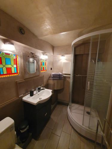 une salle de bain avec un lavabo et une douche dans l'établissement la Villa Mancelle, au Mans