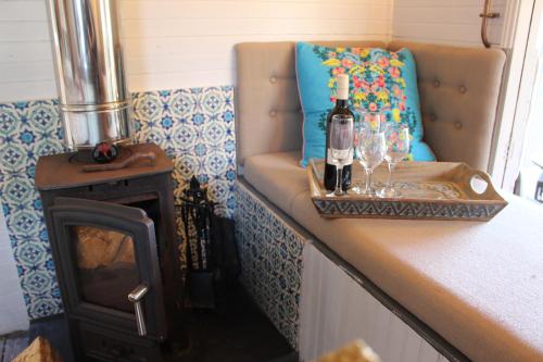 a room with a couch and a bottle of wine on a counter at The Edwardian Caravan 'Dora' in Lampeter
