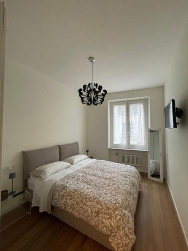 een slaapkamer met een groot bed en een kroonluchter bij Palazzo Penco Apartment in Genua