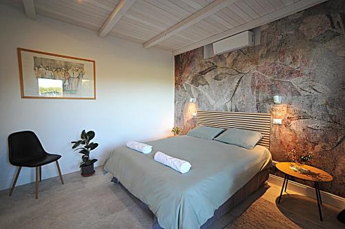 a bedroom with a bed and a rock wall at Tenuta Bussete Country Hotel in Viterbo