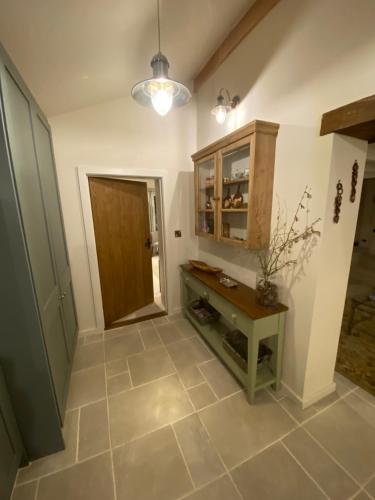 - un couloir doté de carrelage et d'une porte en bois dans l'établissement Gower Villa Luxury Cottage, 2 bedroom en-suite with Hot Tub, à Clynderwen