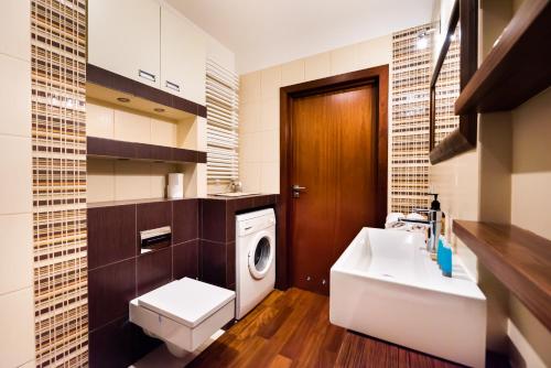 ein Badezimmer mit einer Waschmaschine, einer Waschmaschine und einem Trockner in der Unterkunft Bemowo Green Wood Apartment in Warschau