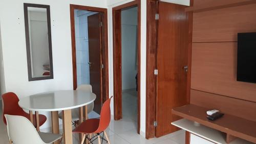 a room with a table and chairs and a television at Jockey Family Chamonix 2 in Vila Velha