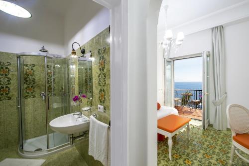 y baño con ducha y lavabo con vistas. en Open Gate, en Praiano