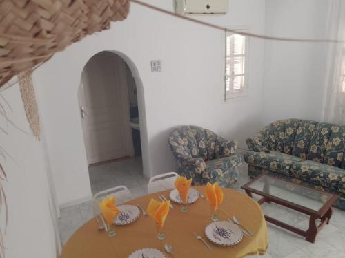 a living room with a table and two couches at Djerba house in Houmt Souk