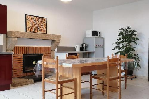 une cuisine avec une table et des chaises ainsi qu'une cheminée dans l'établissement LE PUY DU FOU A 5 KM GITE 4 PERSONNES, à Chambretaud