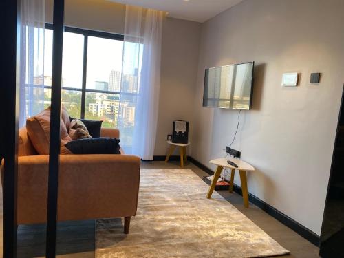 un salon avec un canapé et une télévision à écran plat dans l'établissement Paranais Apartment, à Nairobi
