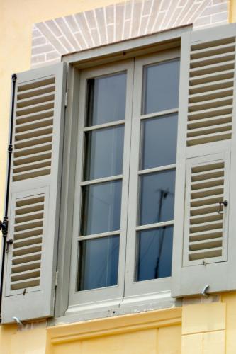 an open window with shutters on a building at Hotel L'Iglesia in El Jadida