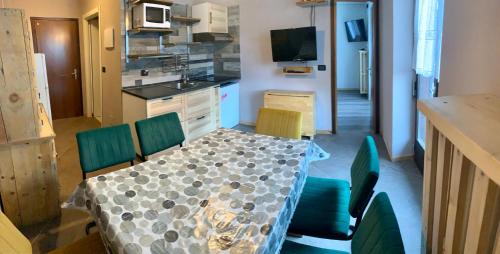uma cozinha com uma mesa e cadeiras numa cozinha em Appartamento Piè em Canazei