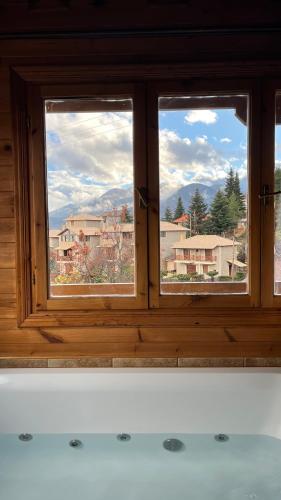 a window with a view of a city from a bath tub at Dryades Suites in Synikia Mesi Trikalon