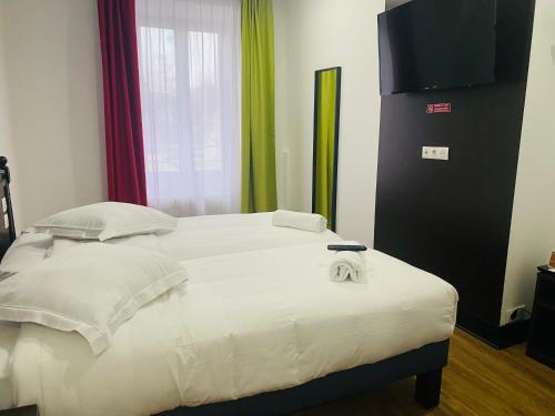 uma cama com duas toalhas num quarto em Enzo Hotels Limoges Centre Jourdan by Kyriad Direct em Limoges