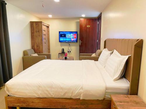1 dormitorio con 1 cama grande y TV en دريم العليا للوحدات السكنية en Al Khobar