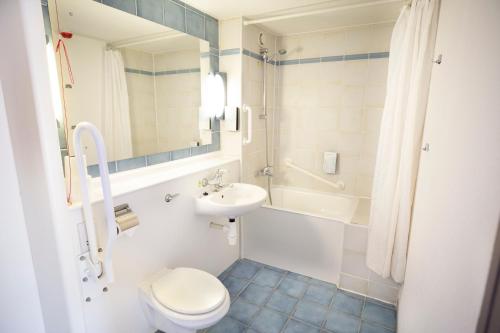巴塞爾頓的住宿－鐘樓倫敦東區巴斯爾登酒店，浴室配有卫生间、盥洗盆和浴缸。
