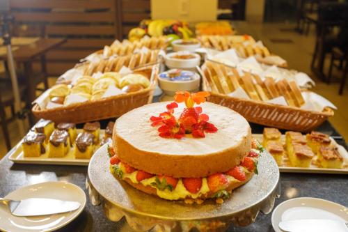 una mesa con un pastel en un plato con otros postres en Interclass Florianópolis, en Florianópolis