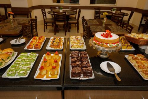 a buffet with many different types of cakes and desserts at Interclass Florianópolis in Florianópolis