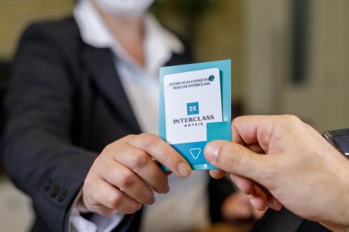 a person holding a credit card in their hands at Interclass Florianópolis in Florianópolis