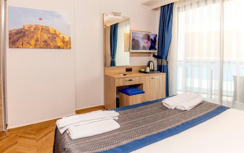 a bedroom with a bed and a desk and a mirror at Relax Beach Hotel in Alanya