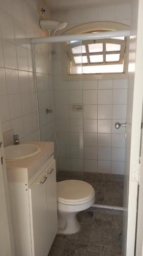 um banheiro com vaso sanitário e pia em Quarto para temporada na praia do corsário em Salvador