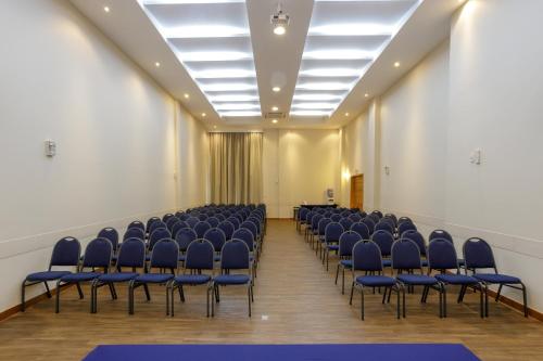 an empty room with blue chairs and a ceiling at Interclass Florianópolis in Florianópolis
