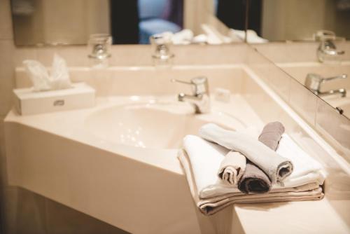 y baño con lavabo, toallas y espejo. en Hotel & Restaurant Zum Vater Rhein, en Monheim