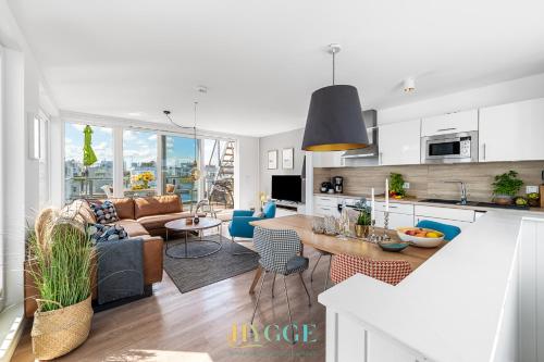 a kitchen and living room with a couch and a table at Schwimmendes Haus Hygge Olpenitz in Olpenitz