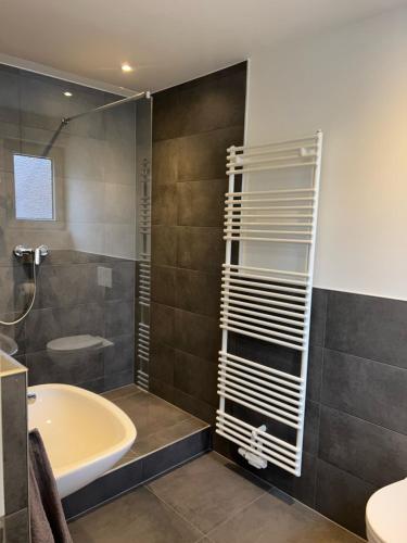 a bathroom with a shower and a tub and a sink at Wohlfühlapartment Braunschweig in Bergisch Gladbach