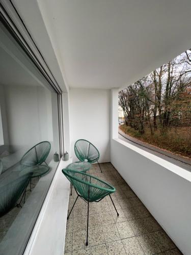 two green chairs in a room with a window at Wohlfühlapartment Braunschweig in Bergisch Gladbach