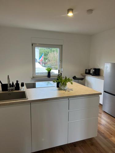 a kitchen with white cabinets and a sink and a window at Wohlfühlapartment Braunschweig in Bergisch Gladbach