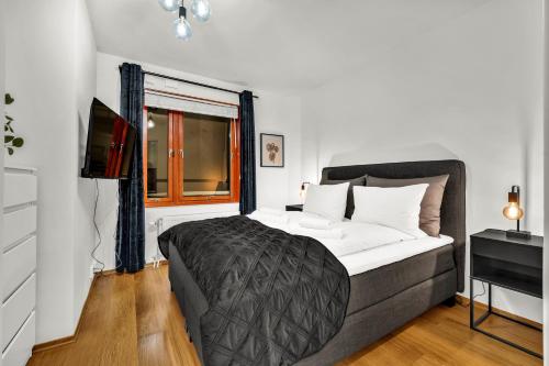 a bedroom with a large bed and a window at Tjuvholmen II, As Home in Oslo